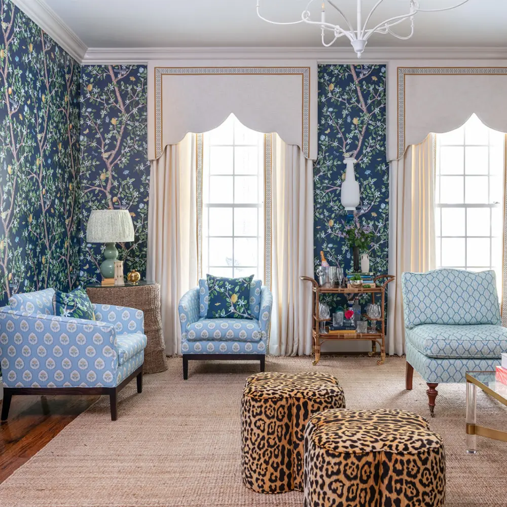 A formal living room with navy blue floral wallpaper and blue upholstered furniture.