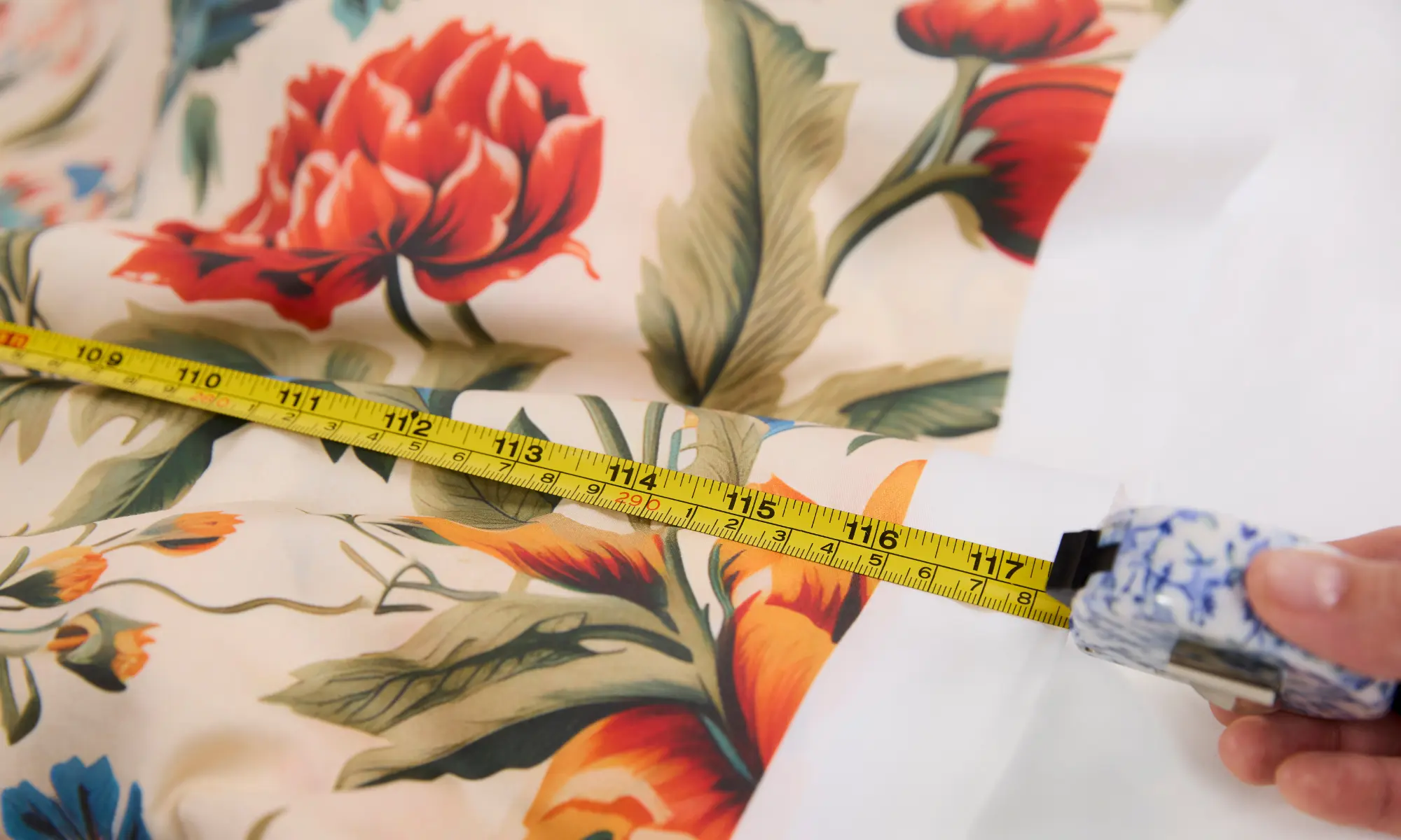 Tape measure showing 116 inches on floral printed extra wide cotton sateen