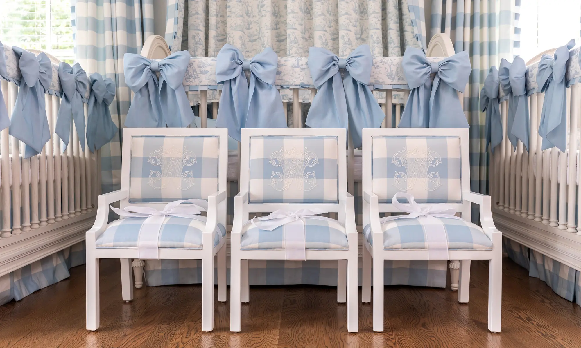 Three cribs with small matching monogramed chairs in a nursery